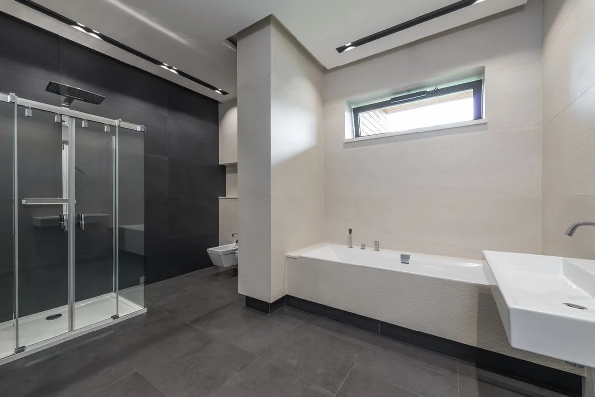 Illustrative finished bathroom with a fitted tub, tiled surfaces and glass shower enclosure